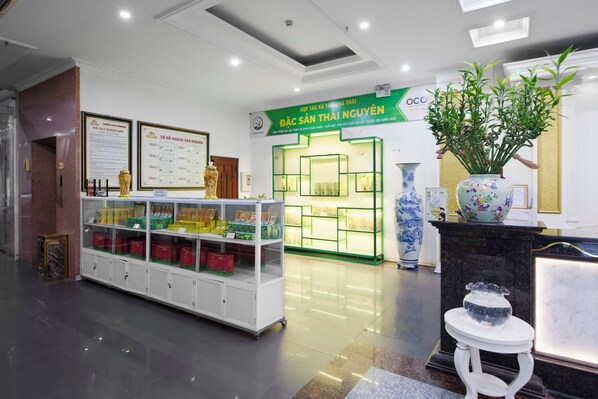 A reception area with a reception desk, a display of products, and a green sign.