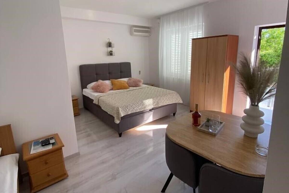 Ein modernes Schlafzimmer mit einem Bett, einem Nachttisch und einem Schreibtisch mit Stuhl.