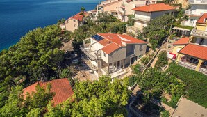 Uma área residencial costeira com casas de telhado vermelho, algumas com varandas, e uma variedade de estilos arquitetônicos.