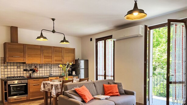 Una cucina moderna con mobili in legno, un tavolo da pranzo e un divano.