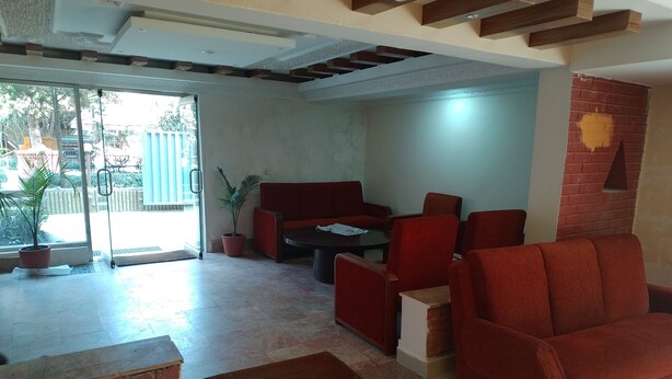 Amplia sala de estar con un sofá rojo, una mesa de centro y una planta en maceta.