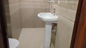 Un baño pequeño con un lavamanos blanco, un inodoro y un espejo.
