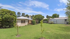 Una propiedad residencial con una casa, un cobertizo y un césped bien cuidado.