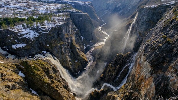 A canyon with a waterfall, rugged terrain, and snow-covered areas. - Fossli Hotel (Eidfjord)