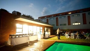 An outdoor pool area with a bar and seating. - Inn Green at The Lofts (Secunda)