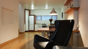 A modern kitchen with a dining area, a black chair, and a pendant light. - Inn Green at The Lofts (Secunda)