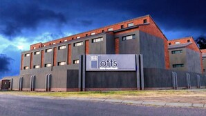 A modern building with a sign reading "The Lofts." - Inn Green at The Lofts (Secunda)