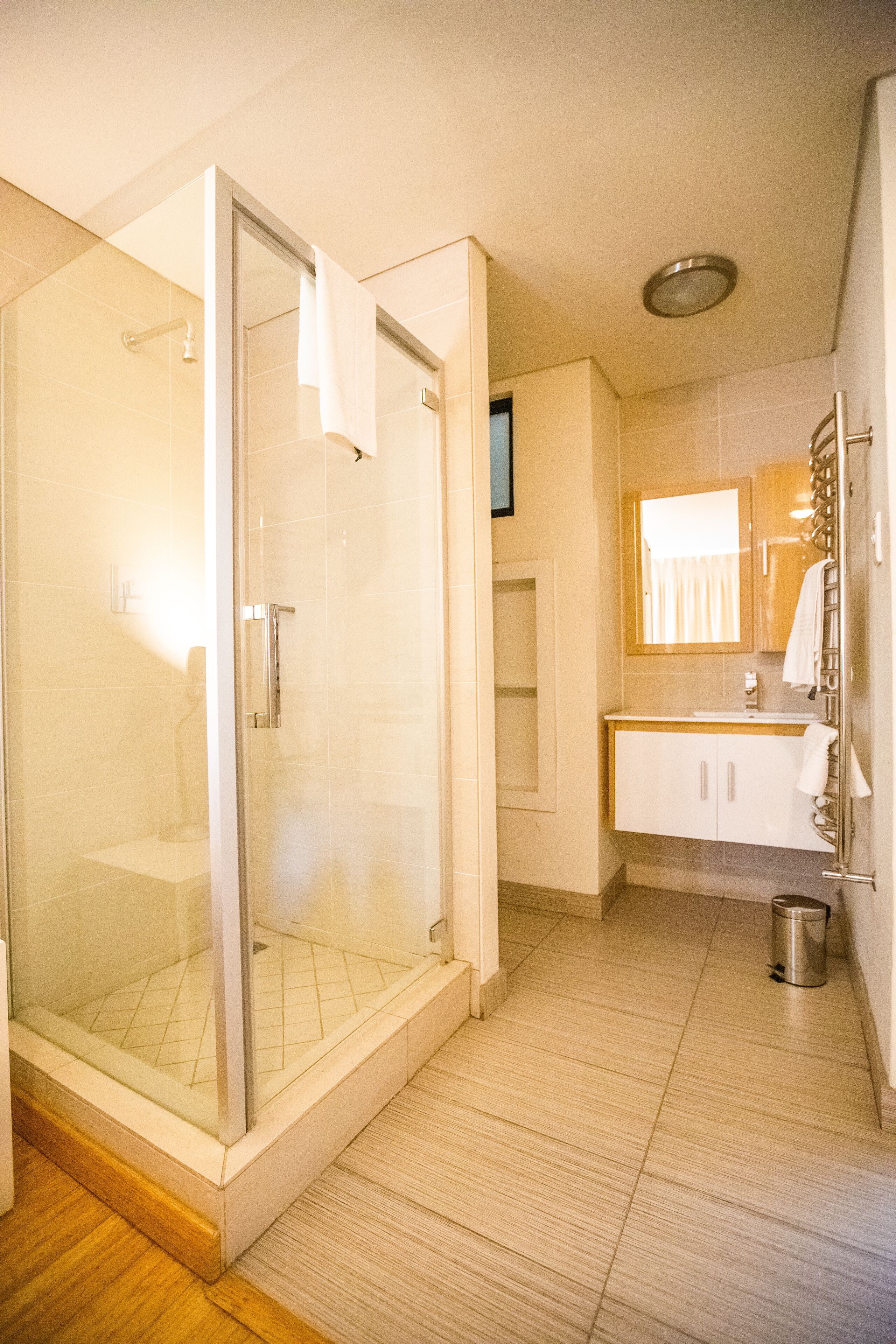 Une salle de bain moderne avec une douche à parois de verre, un lavabo avec un miroir et des toilettes.