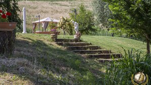 A garden with stone steps leading to a gazebo, surrounded by greenery and a statue. - Villa Gemma, revalue wonder of nature near Lake Bolsena (Narni)