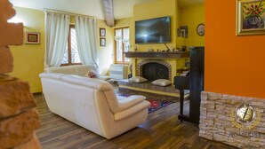 A living room with a fireplace, a television, and a sofa. - Villa Gemma, revalue wonder of nature near Lake Bolsena (Narni)