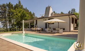 A pool area with a clear pool, outdoor seating, and a building with a tiled roof. - Villa Gemma, revalue wonder of nature near Lake Bolsena (Narni)