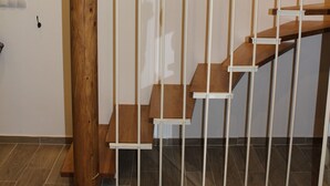 A staircase with wooden steps and white railings, leading to an upper floor. - Casa Karuza (Pag)