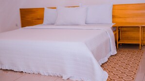 A neatly made bed with white bedding and a wooden headboard. - Green View Apart Hotel (Kigali)