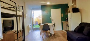 A compact living space with bunk beds, a dining area, a kitchen, and a sofa. - Résidences du Palmier (Saint-Laurent-sur-Sevre)