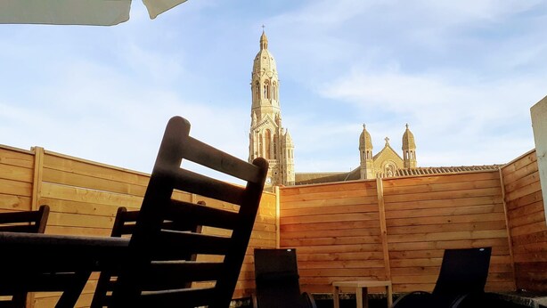 A wooden fence with a view of a tall, ornate building in the background.