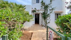 Un edificio blanco con un sendero pavimentado que lleva a la entrada.