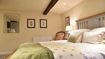 Un dormitorio con cama, un espejo y dos cuadros en la pared.