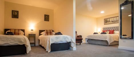 A hotel room with two beds, a large mirror, and a painting on the wall.