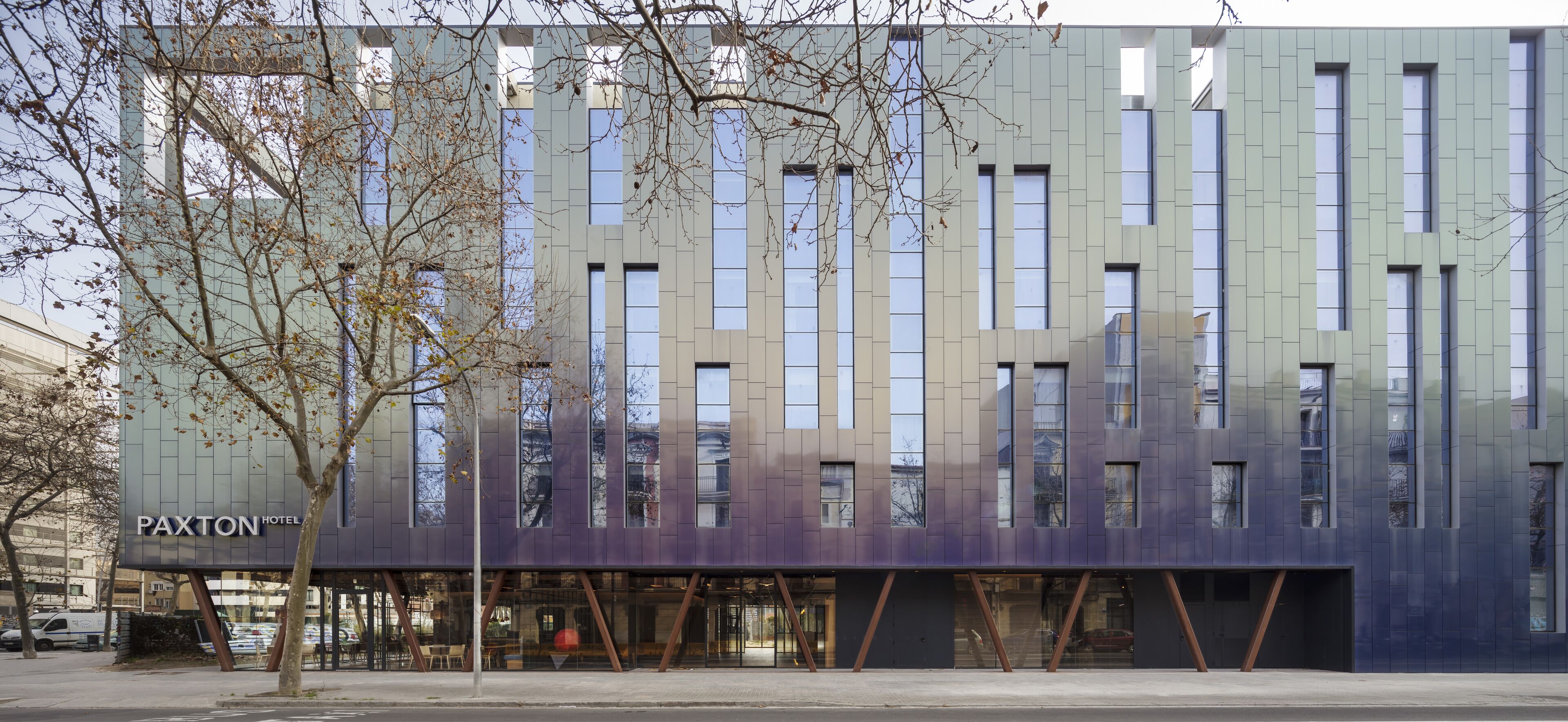Un edificio moderno con fachada de vidrio y un letrero que dice "PAXTON HOTEL".
