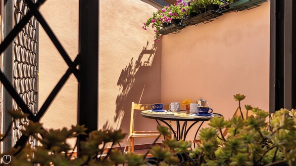 A small round table with a chair, a blue cup, a white cup, and a teapot. - Polese 36 - One Bedroom Apartment, Sleeps 4 (Bologna)