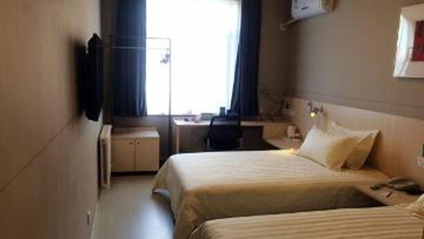 A hotel room with two beds, a desk, a chair, and a window with curtains. - Jinjiang Inn (Beijing)
