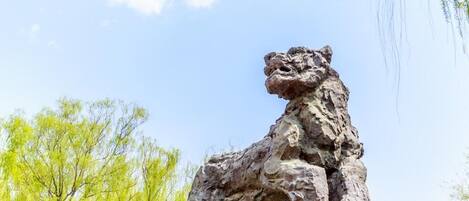 Una gran escultura de piedra con forma de león en un entorno exterior.