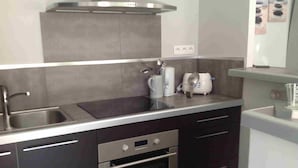 A modern kitchen with a stainless steel sink, a built-in oven, and a toaster. - Air-conditioned villa with garden in the center of Marseillan (Marseillan)