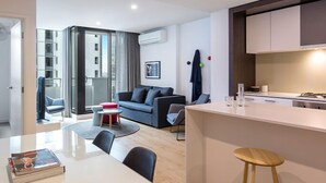 A modern apartment with a living area, dining space, and kitchenette. - Opus tower (Southbank)