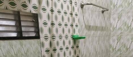 A bathroom with a green sink, a shower, and a toilet.
