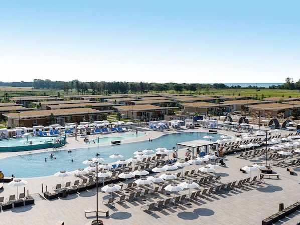 A resort with multiple swimming pools, sun loungers, and umbrellas.