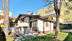 Un immeuble résidentiel de deux étages doté d’un balcon et d’un petit jardin.