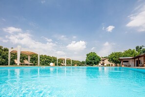 A swimming pool with lounge chairs and a pergola structure.