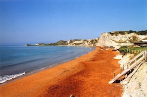 A beach with a wooden walkway and a cliff. - Alekos Beach Houses-Roni (Kefalonia)
