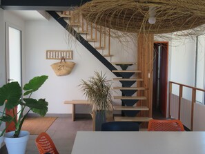 A staircase with wooden steps and a woven ceiling, a white wall with a number '21' basket, and a potted plant. - House in a green setting, with splendid view of the lake and 80m from its beaches! (carcans)
