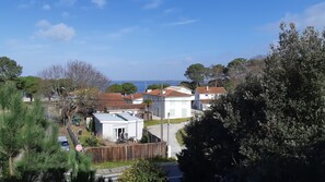 Un quartier résidentiel situé sur la côte, avec des maisons, une clôture en bois et une vue sur la mer.