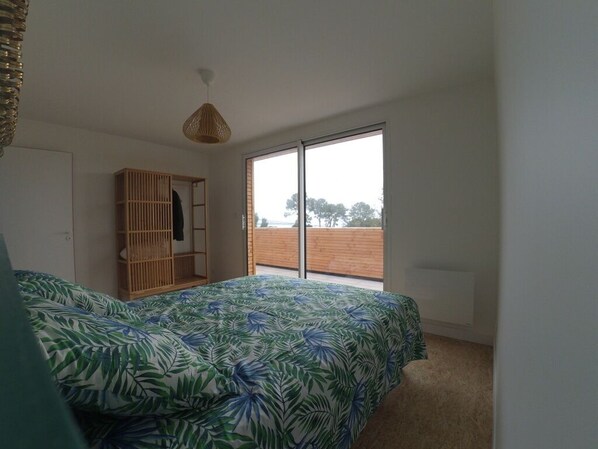 Une chambre à coucher avec un lit, une armoire et une grande fenêtre.