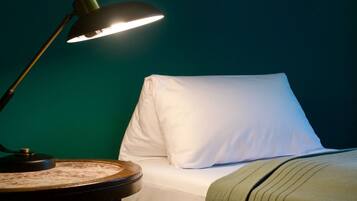 A room with a bed, a bedside table, and a lamp.