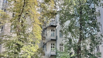 Un edificio de varios pisos con una escalera espiral que conduce a un balcón superior.