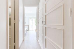 Enter a serene space with a large door leading to a cozy bedroom.
