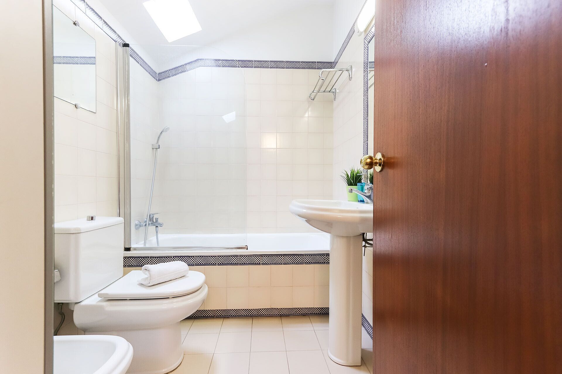 Un baño con inodoro, lavamanos y zona de ducha.