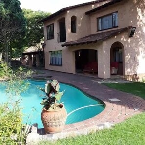 A two-story house with a swimming pool, a patio, and a garden. - Ferndale Lodge (Randburg)