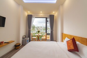 Relax in this inviting room with a large bed, a flat-screen TV, and a small table for two.