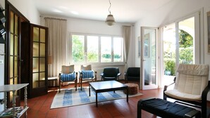 A spacious living room with a large window, a sofa, a coffee table, and two armchairs. - Wonderful private villa for 8 guests with WIFI, TV and terrace (Forte Dei Marmi)