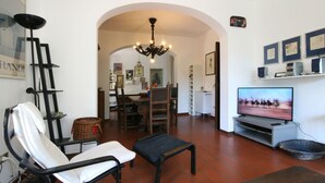 A living room with a TV, a dining area, and a hallway leading to another room. - Wonderful private villa for 8 guests with WIFI, TV and terrace (Forte Dei Marmi)