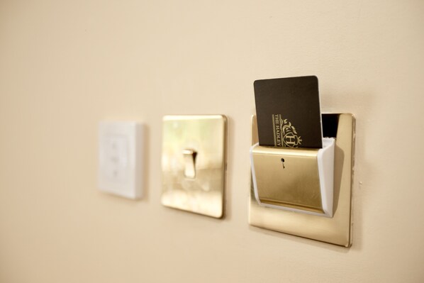 A wall-mounted light switch and a door lock with a card slot.