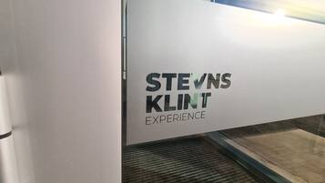 A sign with text in a foreign language, possibly indicating a business or service hours.