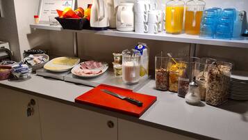 Montaje de un bufé de desayuno con diversas opciones de comida, cafeteras y un cartel que indica la disponibilidad de WiFi.