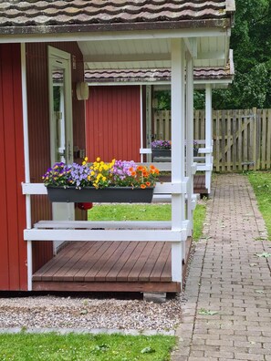 A wooden deck with a planter box of flowers.