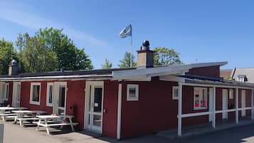 Guest rooms offer windows and access to a communal outdoor area with picnic tables.