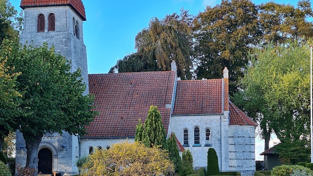 A historic building with a red-tiled roof, a stone tower, and a well-manicured garden with hedges and pathways. - Danhostel Stevns (Store Heddinge)